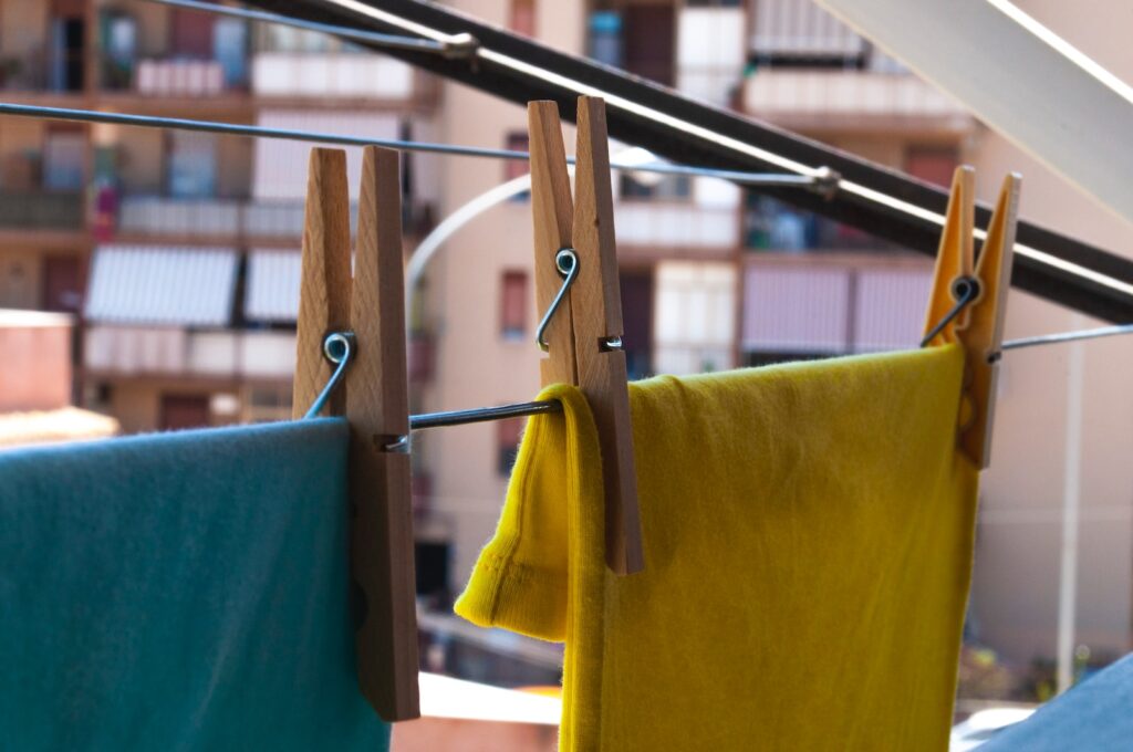 yellow textile on brown wooden clothes hanger