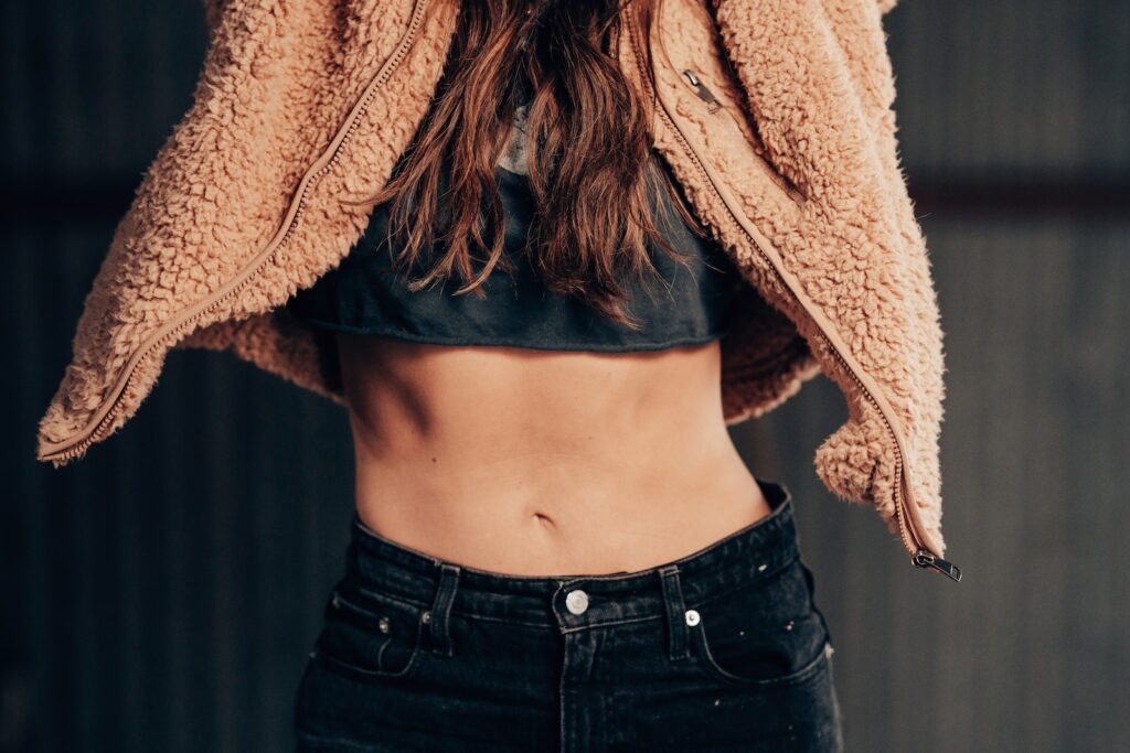 woman in black denim jeans and brown fleece coat