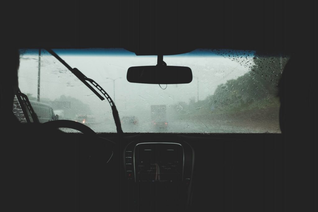 two person driving on rainy road