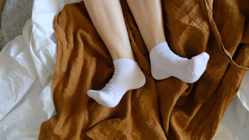 Person in white socks on brown textile