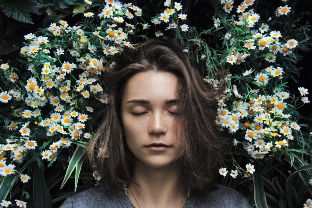 Woman closing her eyes on white flower