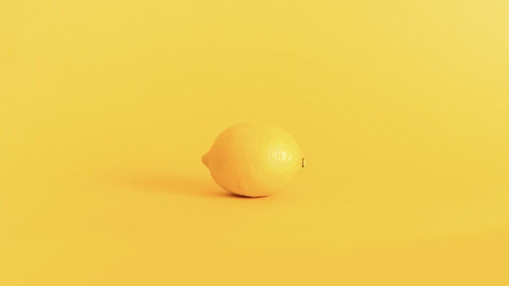 Yellow lemon fruit on yellow surface