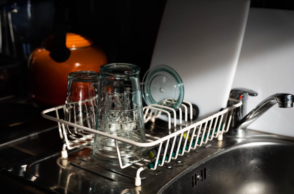 clear glass mugs on white metal rack