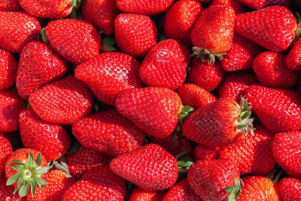 red strawberries on green leaves