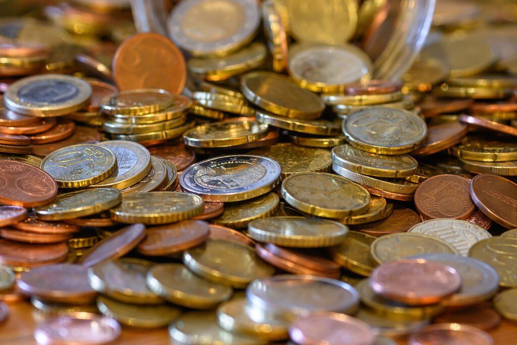 a pile of coins sitting on top of a wooden table