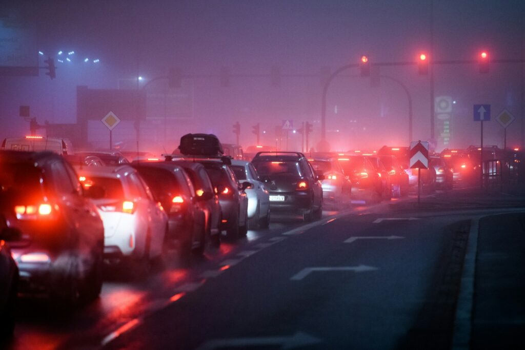 a foggy city street filled with lots of traffic