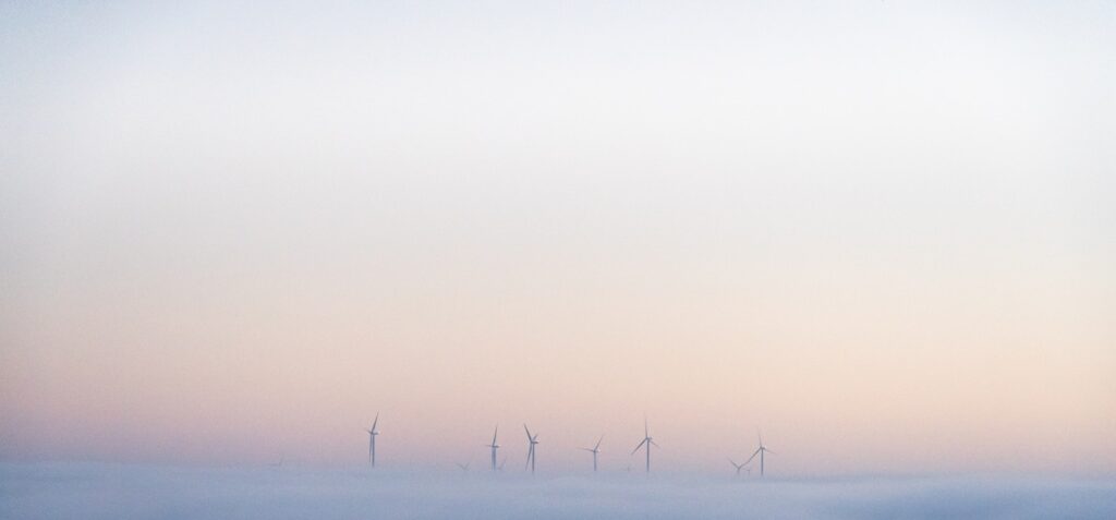 a group of windmills in a foggy field