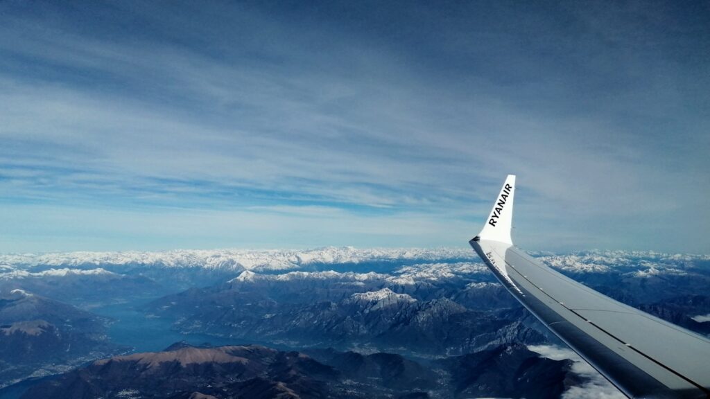 an airplane wing flying over a mountain range