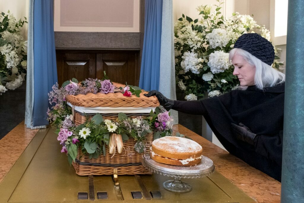 a woman in a black dress and a basket with flowers